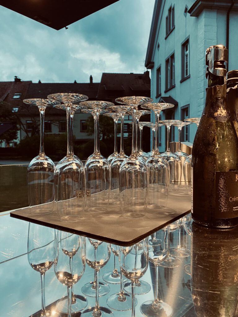 Reihe umgedrehter Gläser neben einer Flasche auf dem Tresen
