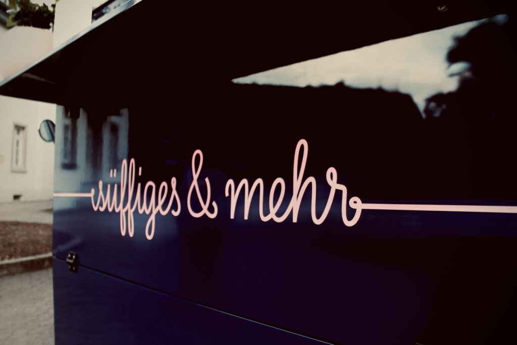 Der Schriftzug süffiges & mehr leuchtet in der Abenddämmerung