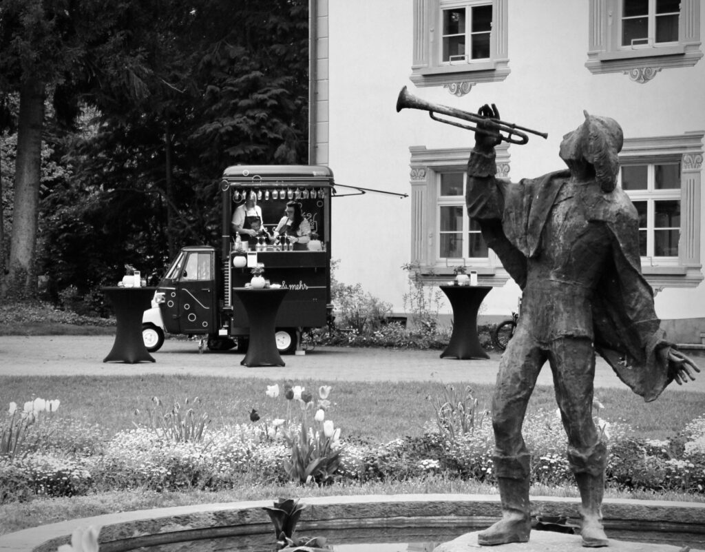 Das Zwuggele vor dem Schloss neben einer Statue